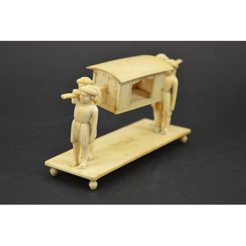 27 - λ A 19th century Indian ivory figure group of a palanquin being carried by four men, 15cm long, 8cm ... 