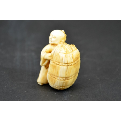 28 - λ A 19th century Japanese carved ivory netsuke, Meiji, modelled as small man with bag of wheat, 4cm ... 