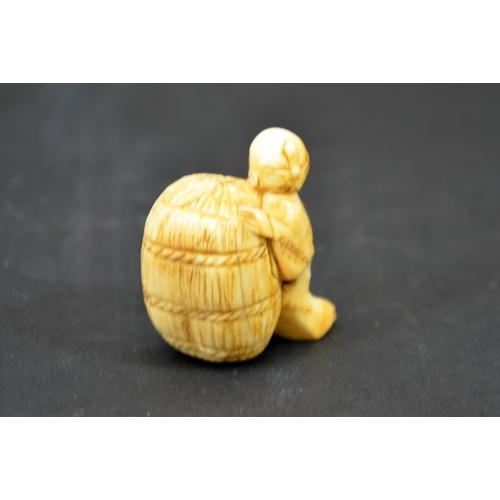 28 - λ A 19th century Japanese carved ivory netsuke, Meiji, modelled as small man with bag of wheat, 4cm ... 