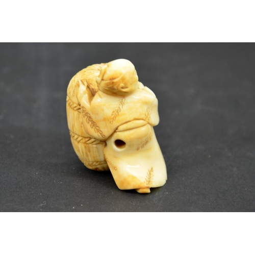 28 - λ A 19th century Japanese carved ivory netsuke, Meiji, modelled as small man with bag of wheat, 4cm ... 