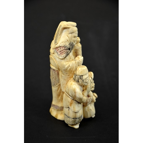 29 - λ A 19th century Japanese carved ivory okimono, modelled as three grotesque figures, holding lantern... 