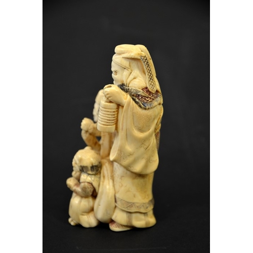 29 - λ A 19th century Japanese carved ivory okimono, modelled as three grotesque figures, holding lantern... 