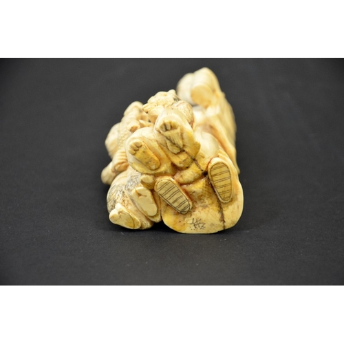 29 - λ A 19th century Japanese carved ivory okimono, modelled as three grotesque figures, holding lantern... 