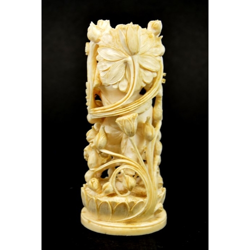 32 - λ A 19th century Indian carved ivory figure of a deity playing the pipe, within a floral cage, stand... 