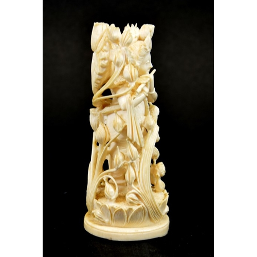 32 - λ A 19th century Indian carved ivory figure of a deity playing the pipe, within a floral cage, stand... 