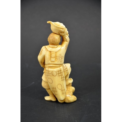 33 - λ A 19th century Japanese carved ivory okimono, Meiji, modelled as a Samurai holding a conch shell, ... 