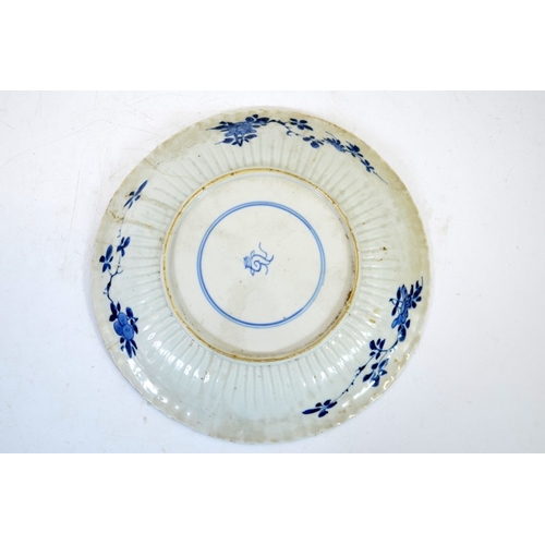 4 - A Chinese blue and white plate, Kangxi, relief moulded ribbed edge, painted with central prunus and ... 