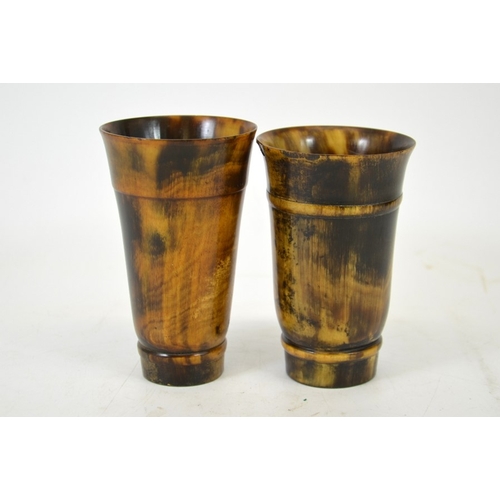 57 - Two 19th century turned horn beakers, one with a glass bottom, each with carved banding, 12.5cm high... 