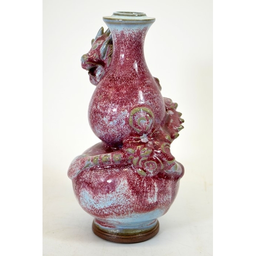 9 - A Chinese double gourd vase, sang de boeuf with relief moulded dragon, entwined, 24cm high