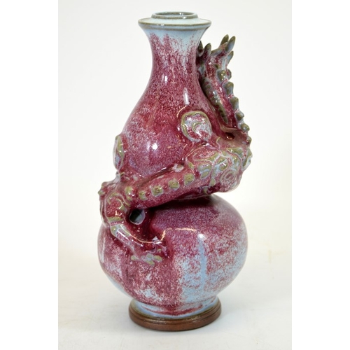 9 - A Chinese double gourd vase, sang de boeuf with relief moulded dragon, entwined, 24cm high