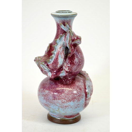 9 - A Chinese double gourd vase, sang de boeuf with relief moulded dragon, entwined, 24cm high