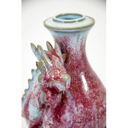 9 - A Chinese double gourd vase, sang de boeuf with relief moulded dragon, entwined, 24cm high