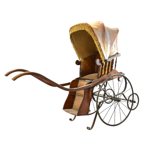 120 - A Victorian wooden pram with brown leather studded hood and interior, on two large wheels with two s... 