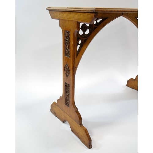 131 - A W N Pugin (attributed), a Gothic Revival oak side table, the two trestle supports carved with ivy ... 