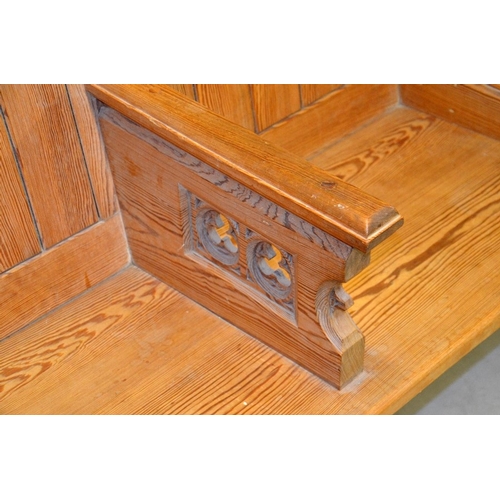 133 - A Gothic Revival pine three seat pew, each arm pierced with trefoil roundels, 183cm long