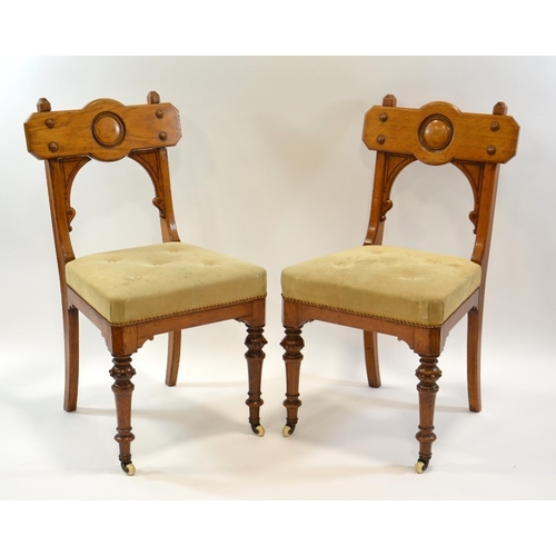 134 - A pair of Gothic Revival oak chairs, circa 1860, the backs with convex roundel and moulded screw cap... 