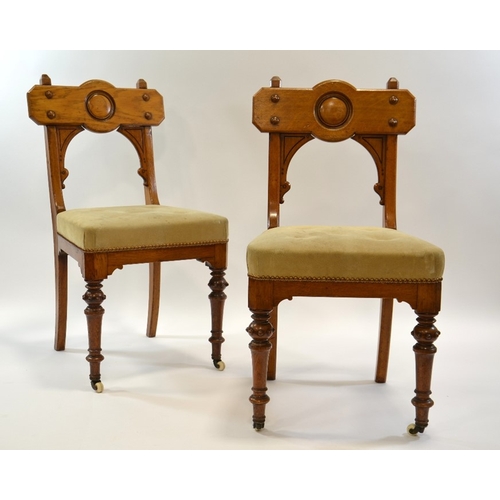 134 - A pair of Gothic Revival oak chairs, circa 1860, the backs with convex roundel and moulded screw cap... 