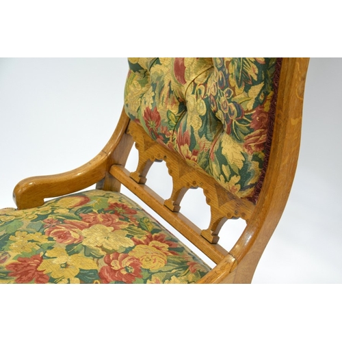 140 - Charles Bevan (attributed), a Gothic Revival oak easy chair, the curved boat back upholstered below ... 