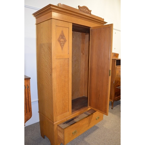 148 - An Arts and Crafts light oak wardrobe, three panel with single mirrored door, flanked by carved loze... 