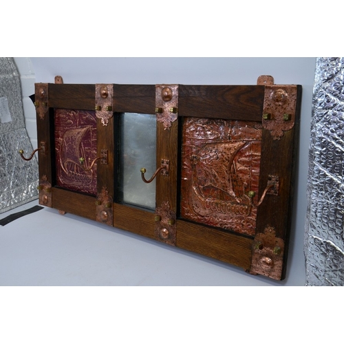 154 - An Arts and Crafts oak mirror wall mounted coat rack, two repoussé copper panels depicting Viking lo... 