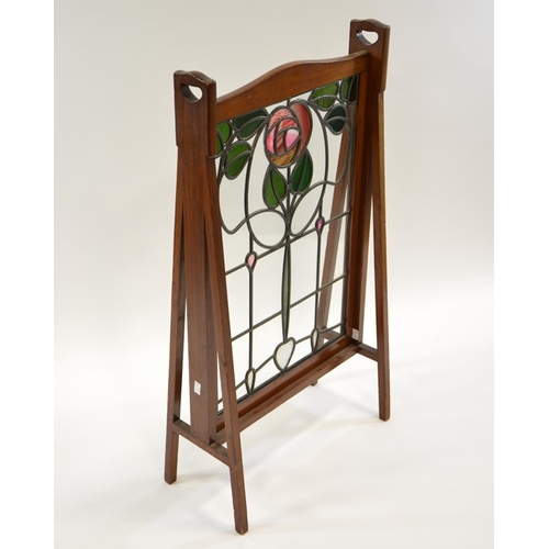 163 - Liberty and Co., an Arts and Crafts mahogany and stained glass fire screen, in the Glasgow style, th... 