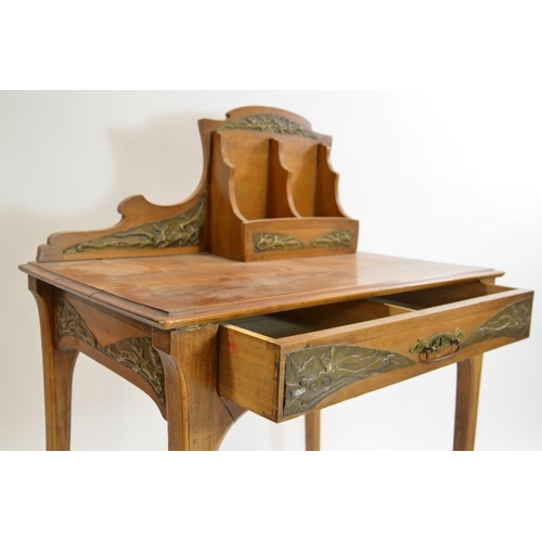 171 - An Art Nouveau writing desk, circa 1900, walnut, with applied repousse brass plaques, the rack with ... 