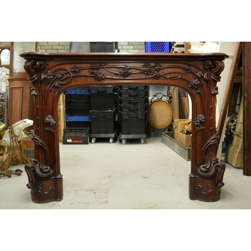 172 - Louis Majorelle (attributed), a large Art Nouveau carved walnut fire surround, circa 1900, modelled ... 