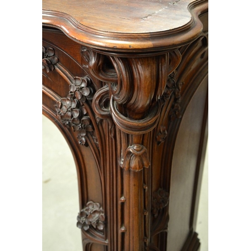 172 - Louis Majorelle (attributed), a large Art Nouveau carved walnut fire surround, circa 1900, modelled ... 