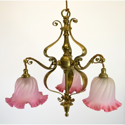 222 - An Arts and Crafts brass pendant light fitting, with three pink opaque glass shades, circa 1900, in ... 