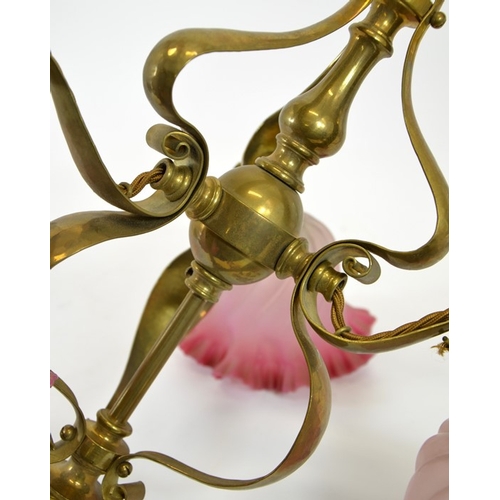 222 - An Arts and Crafts brass pendant light fitting, with three pink opaque glass shades, circa 1900, in ... 