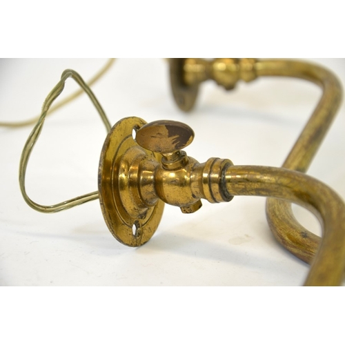 224 - A pair of Arts and Crafts brass wall lights with frosted glass shades, curved tubular arms supportin... 