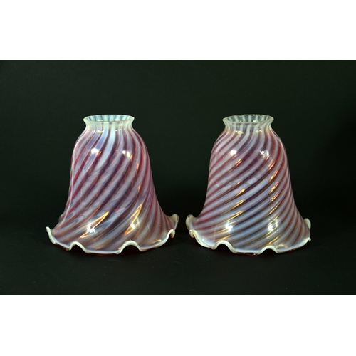 299 - A pair of Arts and Crafts cranberry and opaque glass light shades, wrythen stripe design with crimpe... 