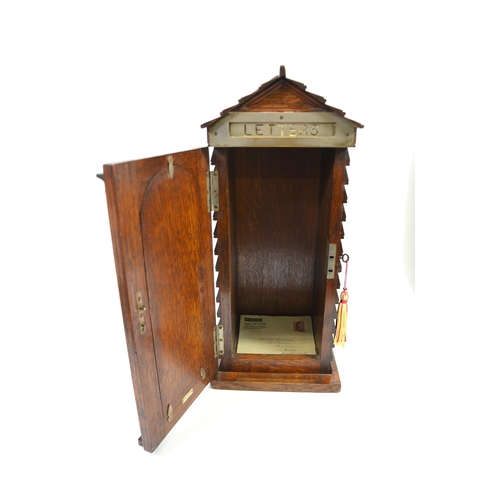 96 - A Victorian Country House oak letter box, in the form of a sentry box, the glazed door painted with ... 