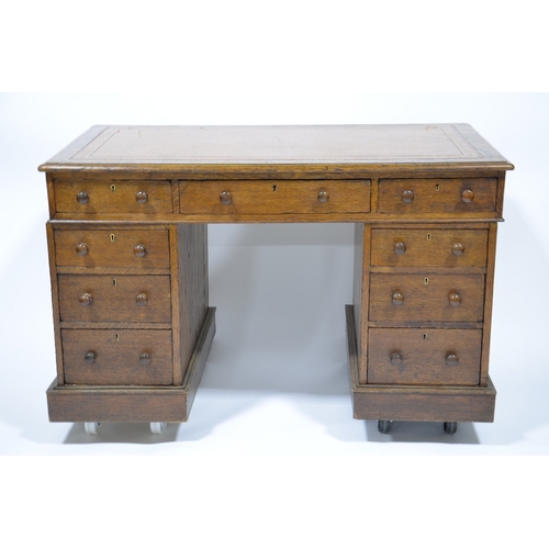 114 - An Edwardian oak pedestal desk, with leather inset top, with three graduated drawers to each support... 