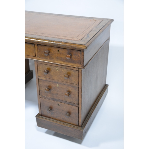 114 - An Edwardian oak pedestal desk, with leather inset top, with three graduated drawers to each support... 