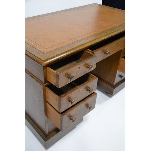 114 - An Edwardian oak pedestal desk, with leather inset top, with three graduated drawers to each support... 