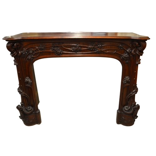 172 - Louis Majorelle (attributed), a large Art Nouveau carved walnut fire surround, circa 1900, modelled ... 