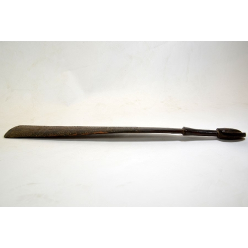 27 - A tribal carved wood club, 19th or 20th century, the paddle blade with stylised wave design, 67cm lo... 