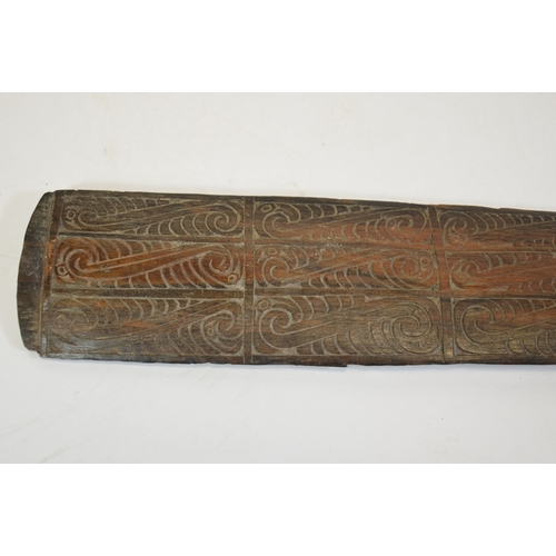 27 - A tribal carved wood club, 19th or 20th century, the paddle blade with stylised wave design, 67cm lo... 