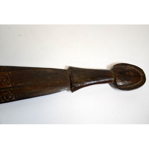 27 - A tribal carved wood club, 19th or 20th century, the paddle blade with stylised wave design, 67cm lo... 