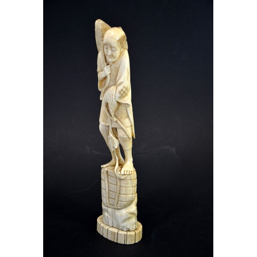 61 - λ A 19th century Japanese carved ivory okimono, Meiji, modelled as a fisherman with baskets and hat,... 