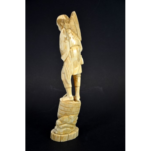 61 - λ A 19th century Japanese carved ivory okimono, Meiji, modelled as a fisherman with baskets and hat,... 