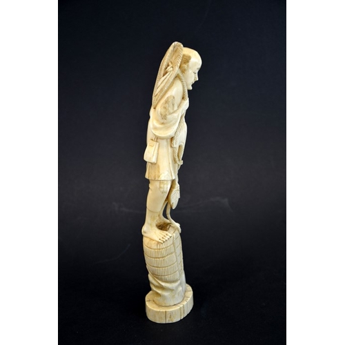 61 - λ A 19th century Japanese carved ivory okimono, Meiji, modelled as a fisherman with baskets and hat,... 