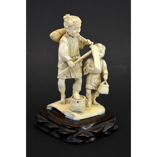 62 - λ A 19th century Japanese carved ivory okimono, Meiji, modelled as an elderly farmer and boy, carryi... 