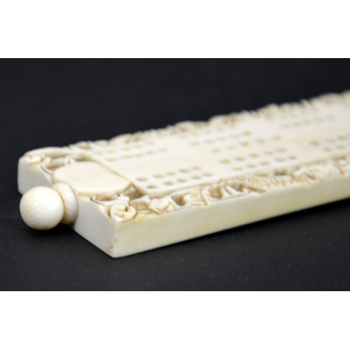 63 - λ A 19th century Chinese carved ivory cribbage board, wedge form, decorated with dragons, 21.5cm lon... 