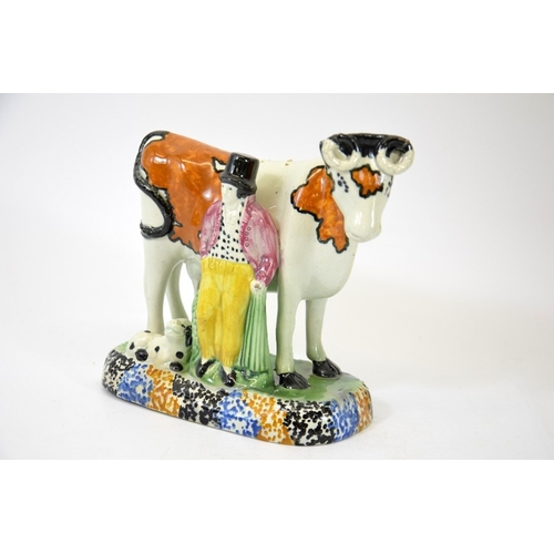 1313 - A Staffordshire prattware figure of a cow, man and dog, circa 1810, 15cm high