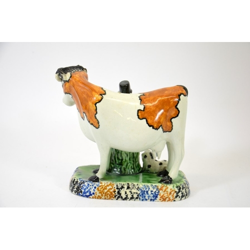 1313 - A Staffordshire prattware figure of a cow, man and dog, circa 1810, 15cm high