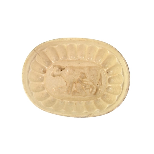 1316 - An English creamware jelly mould, circa 1800, with a incuse moulded image of a cow and milkmaid, 13c... 