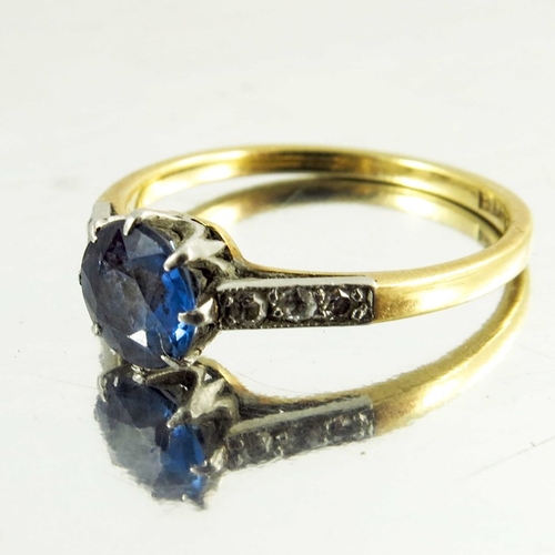 125 - A sapphire and diamond ring, on 18 carat gold band, the central solitaire stone, approx. 6mm diamete... 