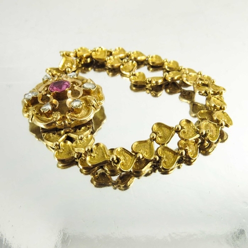 130 - A Victorian gold, diamond and ruby bracelet, the cast heart linked double chain band with foliate sc... 